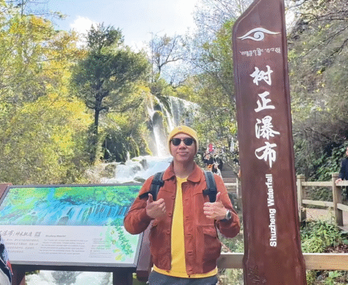 Me posing at Shù zhèng pùbù (树正瀑布) Signboard - Jiuzhaigou Travel Guide: Magical Valley - Leo Trails