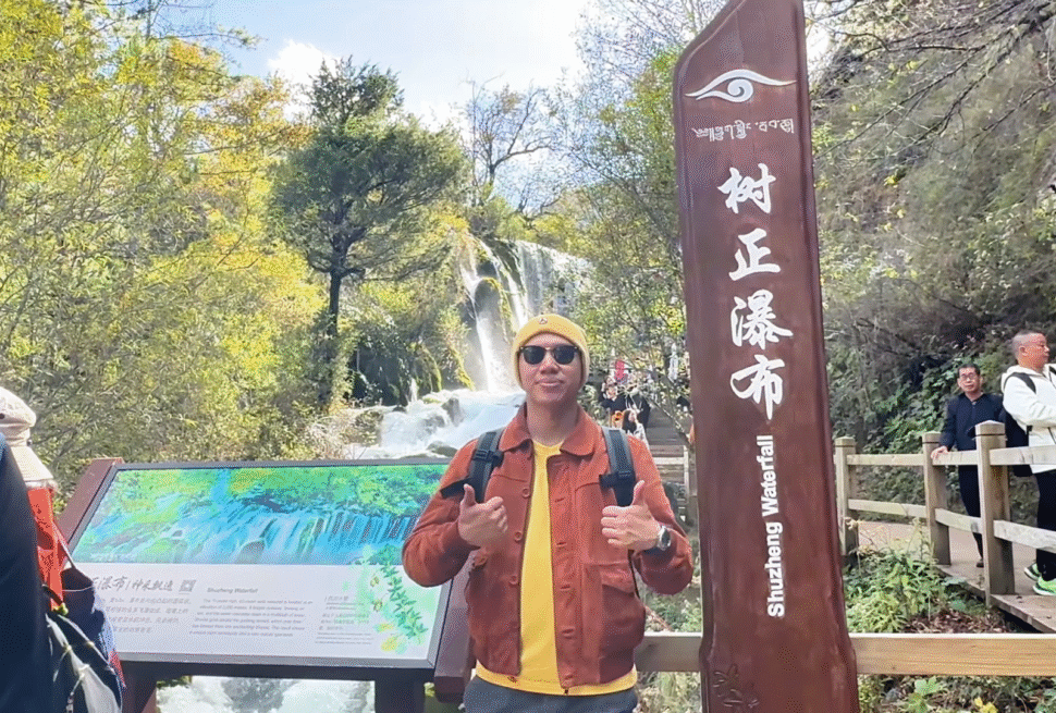 Me posing at Shù zhèng pùbù (树正瀑布) Signboard - Jiuzhaigou Travel Guide: Magical Valley - Leo Trails