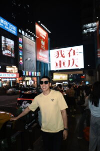 Me posing at Wǒ zài Chóngqìng (我在重庆) Billboard - Ultimate Chongqing Itinerary: 7 Top Attractions - Leo Trails