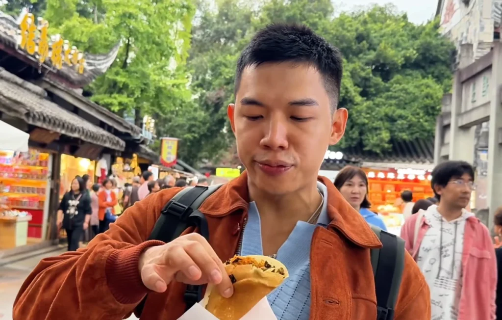 Me holding Dan Hong Gao - Best Street Snacks in Jinli, Chengdu - Leotrails