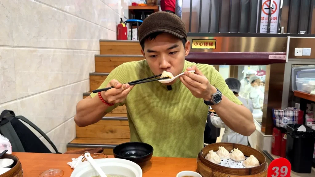 eating small bite of Xiao long Bao - A Simple Guide on How to Eat Xiao Long Bao the Right Way - Leotrails