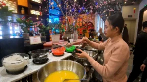 A lady taking some jellies from the table counter - How to Buy Fansipan Mountain Tickets the Easy Way 🎟️ - Leotrails