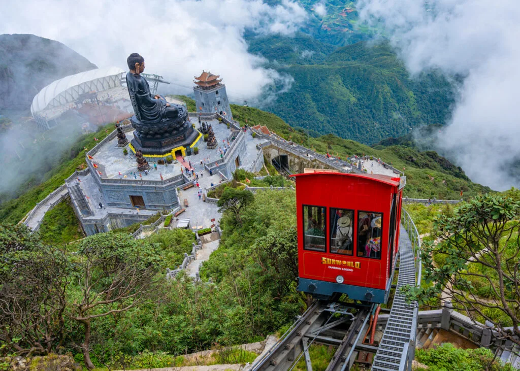 The Fansipan Peak Rail passing right by the Great Buddha Statue. - How to Buy Fansipan Mountain Tickets the Easy Way 🎟️ - Leotrails