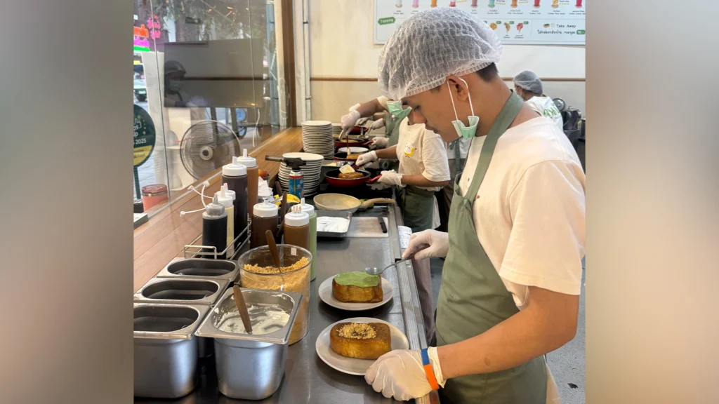 Staff preparing June Pang's signature caramelized toast at the open kitchen in Bangkok