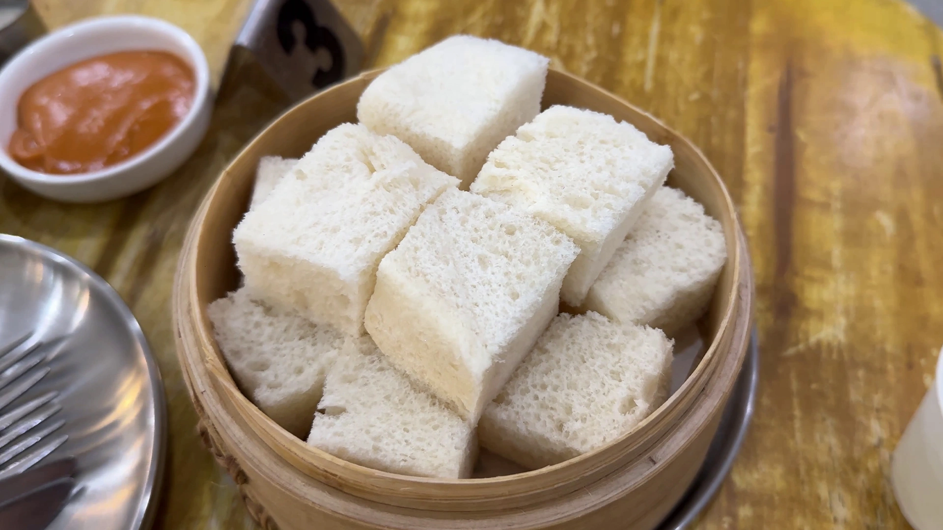 Steamed white bread served with Thai tea and pandan custards at Junpang in Bangkok