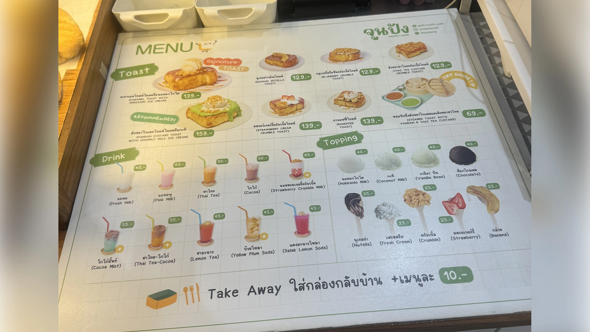 Menu board at June Pang showing toast, drinks, and topping prices