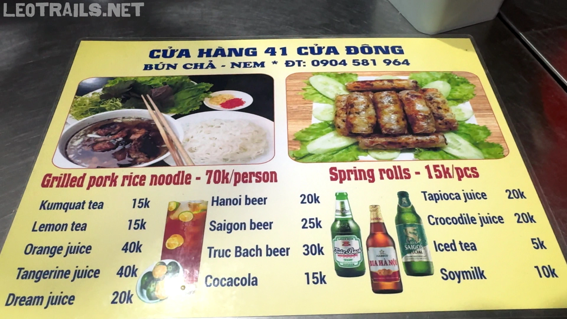 The English and Vietnamese menu of Bún Chả 41 Cửa Đông showing prices for grilled pork rice noodles, spring rolls, juices, and local beers