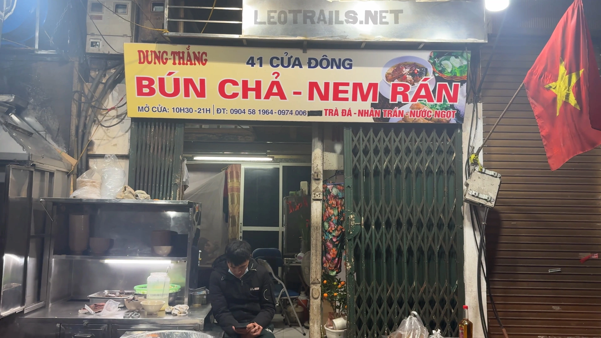 The street-facing storefront of Bún Chả 41 Cửa Đông in Hanoi, Vietnam, showing a yellow and red sign that reads "Dung Thắng - Bún Chả - Nem Rán