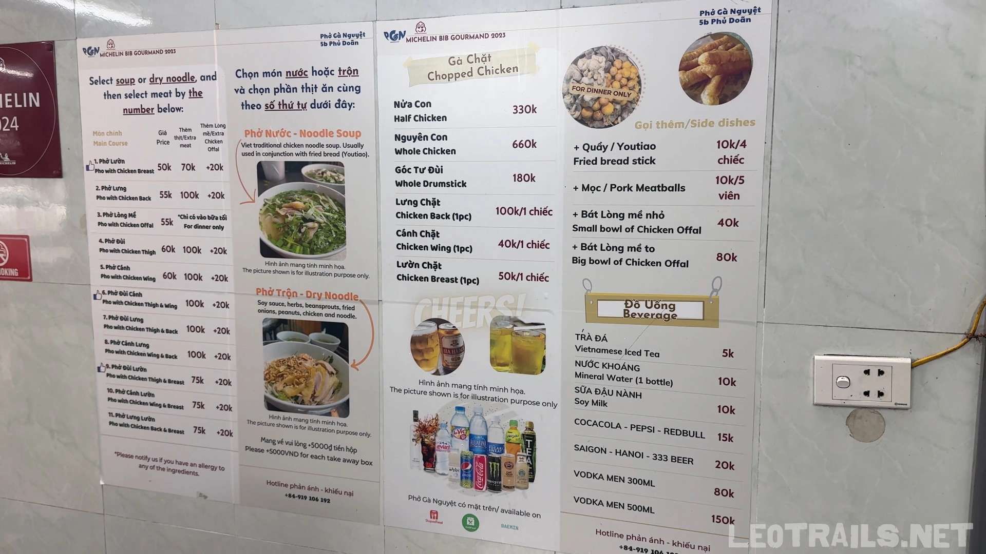 The large wall menu of Phở Gà Nguyệt restaurant displaying options for noodle soup, dry noodles, chopped chicken parts, and beverages with prices in Vietnamese Dong.